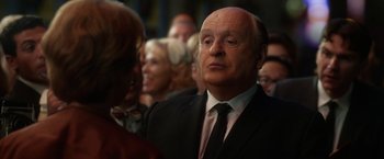 Movie still from “Hitchcock” (2012), directed by Sacha Gervasi – An older man in a suit and tie looking up; Close Up shot, Over the shoulder angle