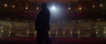 Movie still from “Hitchcock” (2012), directed by Sacha Gervasi – A man walking on a stage in front of an audience; Extreme Wide shot, Low angle