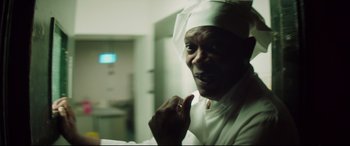 Movie still from “Hitman's Wife's Bodyguard” (2021), directed by Patrick Hughes – A man wearing a white hat is looking at the camera; Close Up shot, Low angle