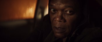 Movie still from “Hitman's Wife's Bodyguard” (2021), directed by Patrick Hughes – An older man looking into the distance with a serious look; Close Up shot, Over the shoulder angle