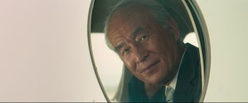 Movie still from “Hitman's Wife's Bodyguard” (2021), directed by Patrick Hughes – An older man looking at himself in a mirror; Close Up shot, Low angle