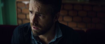 Movie still from “Hitman's Wife's Bodyguard” (2021), directed by Patrick Hughes – A person with a beard looking to his left; Close Up shot, Over the shoulder angle