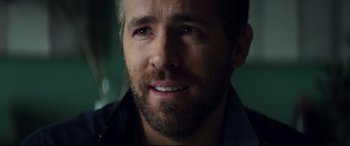 Movie still from “Hitman's Wife's Bodyguard” (2021), directed by Patrick Hughes – A man with a beard looking at the camera; Close Up shot, Over the shoulder angle