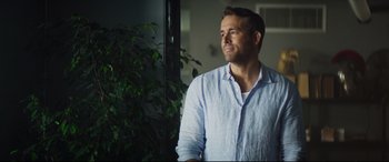 Movie still from “Hitman's Wife's Bodyguard” (2021), directed by Patrick Hughes – A man standing in front of a window looking up; Close Up shot, Over the shoulder angle