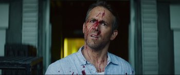 Movie still from “Hitman's Wife's Bodyguard” (2021), directed by Patrick Hughes – A person with blood on his face; Close Up shot, Over the shoulder angle