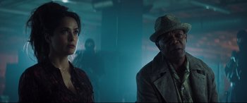 Movie still from “Hitman's Wife's Bodyguard” (2021), directed by Patrick Hughes – A man and a woman are standing in a dark room; Close Up shot, Over the shoulder angle