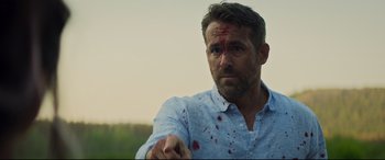 Movie still from “Hitman's Wife's Bodyguard” (2021), directed by Patrick Hughes – A person with blood on his face; Close Up shot, Over the shoulder angle