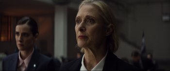 Movie still from “Hitman's Wife's Bodyguard” (2021), directed by Patrick Hughes – An older woman with blonde hair wearing a black suit; Close Up shot, Low angle