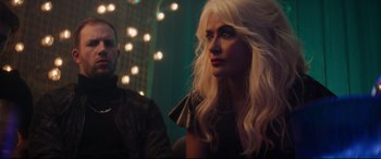 Movie still from “Hitman's Wife's Bodyguard” (2021), directed by Patrick Hughes – A woman with long white hair sitting next to a man; Close Up shot, Over the shoulder angle