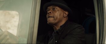 Movie still from “Hitman's Wife's Bodyguard” (2021), directed by Patrick Hughes – An older man wearing a hat and a black jacket; Close Up shot, Low angle