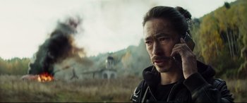 Movie still from “Hitman's Wife's Bodyguard” (2021), directed by Patrick Hughes – A man in a black jacket is talking on a phone; Close Up shot, Low angle