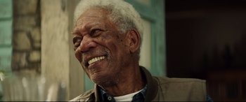 Movie still from “Hitman's Wife's Bodyguard” (2021), directed by Patrick Hughes – An older man with white hair smiling for the camera; Close Up shot, Low angle