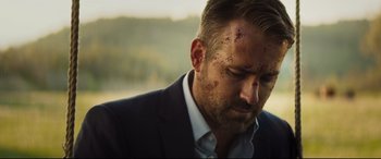 Movie still from “Hitman's Wife's Bodyguard” (2021), directed by Patrick Hughes – A person wearing a suit; Close Up shot, Over the shoulder angle