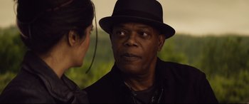 Movie still from “Hitman's Wife's Bodyguard” (2021), directed by Patrick Hughes – An older man wearing a black hat talking to a younger woman; Close Up shot, Over the shoulder angle