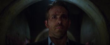 Movie still from “Hitman's Wife's Bodyguard” (2021), directed by Patrick Hughes – A person wearing a suit and tie; Close Up shot, Low angle