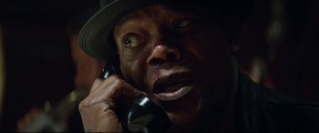 Movie still from “Hitman's Wife's Bodyguard” (2021), directed by Patrick Hughes – A person talking on a cell phone; Close Up shot, High angle