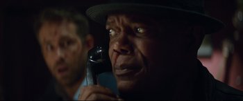 Movie still from “Hitman's Wife's Bodyguard” (2021), directed by Patrick Hughes – An older man holding a cell phone up to his ear; Close Up shot, Low angle