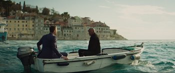 Movie still from “Hitman's Wife's Bodyguard” (2021), directed by Patrick Hughes – Two people sitting on a boat in the water; Wide shot, Over the shoulder angle