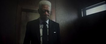 Movie still from “Hitman's Wife's Bodyguard” (2021), directed by Patrick Hughes – An older man in a suit and tie looking sad; Close Up shot, Low angle