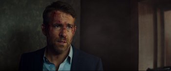 Movie still from “Hitman's Wife's Bodyguard” (2021), directed by Patrick Hughes – A person wearing a suit and shirt; Close Up shot, Over the shoulder angle