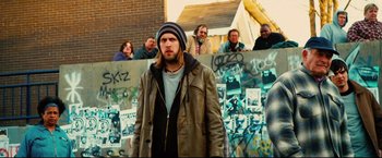 Movie still from “Hobo with a Shotgun” (2011), directed by Jason Eisener – A group of people standing in front of a wall; Medium shot, Low angle