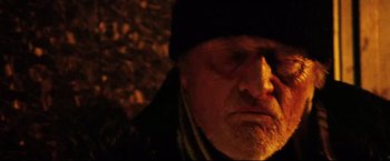 Movie still from “Hobo with a Shotgun” (2011), directed by Jason Eisener – An old man with a beard wearing a black hat; Close Up shot, Low angle