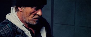 Movie still from “Hobo with a Shotgun” (2011), directed by Jason Eisener – An older man with a beard and a hat; Close Up shot, Low angle