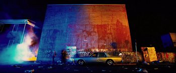 Movie still from “Hobo with a Shotgun” (2011), directed by Jason Eisener – A car parked in front of a brick wall; Extreme Wide shot, Low angle