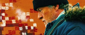 Movie still from “Hobo with a Shotgun” (2011), directed by Jason Eisener – An old man with a beard wearing a black hat; Close Up shot, Low angle