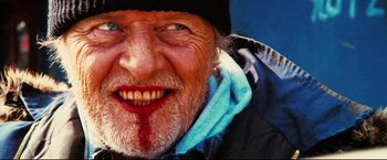 Movie still from “Hobo with a Shotgun” (2011), directed by Jason Eisener – An old man with blood on his face and teeth; Extreme Close Up shot, Low angle