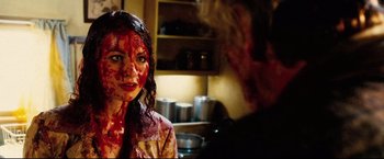 Movie still from “Hobo with a Shotgun” (2011), directed by Jason Eisener – A woman with blood all over her face; Close Up shot, Over the shoulder angle