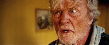 Movie still from “Hobo with a Shotgun” (2011), directed by Jason Eisener – An older man with a beard and a mustache; Close Up shot, Low angle