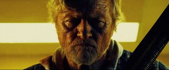 Movie still from “Hobo with a Shotgun” (2011), directed by Jason Eisener – An old man with a very wrinkled face; Close Up shot, Low angle