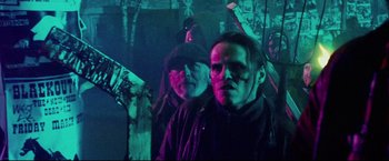 Movie still from “Hobo with a Shotgun” (2011), directed by Jason Eisener – A group of men standing next to each other in a dark room; Medium shot, Low angle