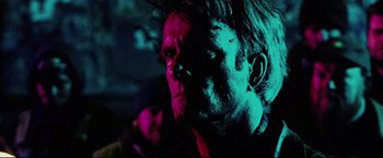 Movie still from “Hobo with a Shotgun” (2011), directed by Jason Eisener – A person with a pink light on their face; Close Up shot, Low angle