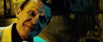 Movie still from “Hobo with a Shotgun” (2011), directed by Jason Eisener – A person's face in a dark room; Close Up shot, Low angle