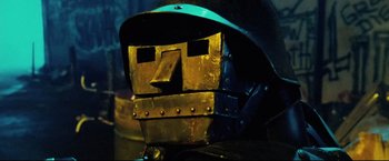Movie still from “Hobo with a Shotgun” (2011), directed by Jason Eisener – The face of an iron man helmet; Extreme Close Up shot, Low angle
