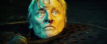 Movie still from “Hobo with a Shotgun” (2011), directed by Jason Eisener – An old man with a beard and a black jacket; Close Up shot, Overhead angle