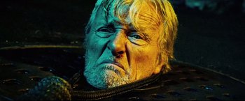 Movie still from “Hobo with a Shotgun” (2011), directed by Jason Eisener – An old man with a white beard and blue eyes; Close Up shot, Low angle