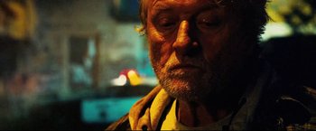 Movie still from “Hobo with a Shotgun” (2011), directed by Jason Eisener – An older man with a beard and a yellow jacket; Close Up shot, Low angle