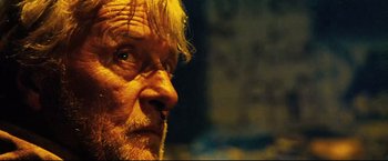 Movie still from “Hobo with a Shotgun” (2011), directed by Jason Eisener – An older man with a beard and a mustache; Close Up shot, Low angle