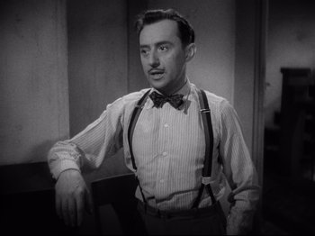 Movie still from “Hold Back the Dawn” (1941), directed by Mitchell Leisen – A black and white photo of a man wearing suspenders; Close Up shot, High angle