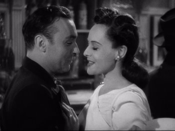 Movie still from “Hold Back the Dawn” (1941), directed by Mitchell Leisen – A man and a woman standing next to each other; Close Up shot, High angle