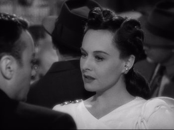 Movie still from “Hold Back the Dawn” (1941), directed by Mitchell Leisen – A woman in a white dress and a man in a black suit; Close Up shot, Over the shoulder angle