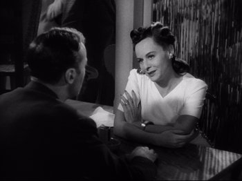 Movie still from “Hold Back the Dawn” (1941), directed by Mitchell Leisen – A man and a woman sitting at a table talking to each other; Medium shot, Over the shoulder angle