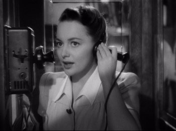 Movie still from “Hold Back the Dawn” (1941), directed by Mitchell Leisen – A black - and - white photo of a woman listening to music; Close Up shot, High angle