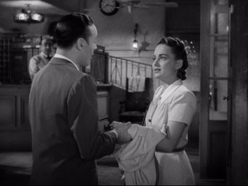 Movie still from “Hold Back the Dawn” (1941), directed by Mitchell Leisen – A man and a woman shaking hands in a room; Medium shot, High angle