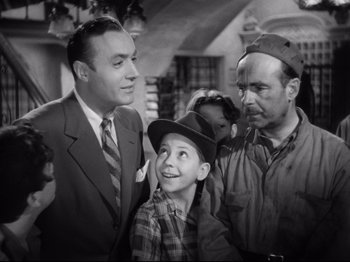 Movie still from “Hold Back the Dawn” (1941), directed by Mitchell Leisen – A group of men standing next to each other in a room; Medium shot, Low angle