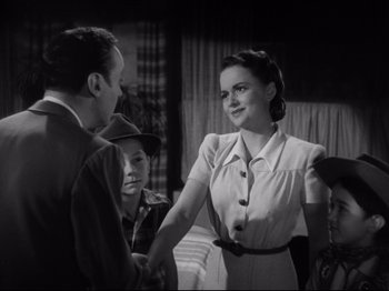 Movie still from “Hold Back the Dawn” (1941), directed by Mitchell Leisen – An old photo of a man and a woman shaking hands; Medium shot, High angle