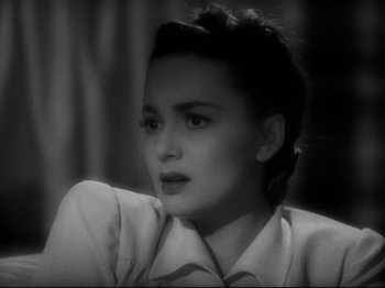 A black - and - white photo of a woman looking at the camera